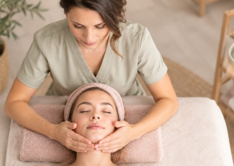 Kozmetičarka pruža tretman lica klijentkinji u mirnom spa ambijentu, uz nežne neutralne tonove i opuštajuću atmosferu